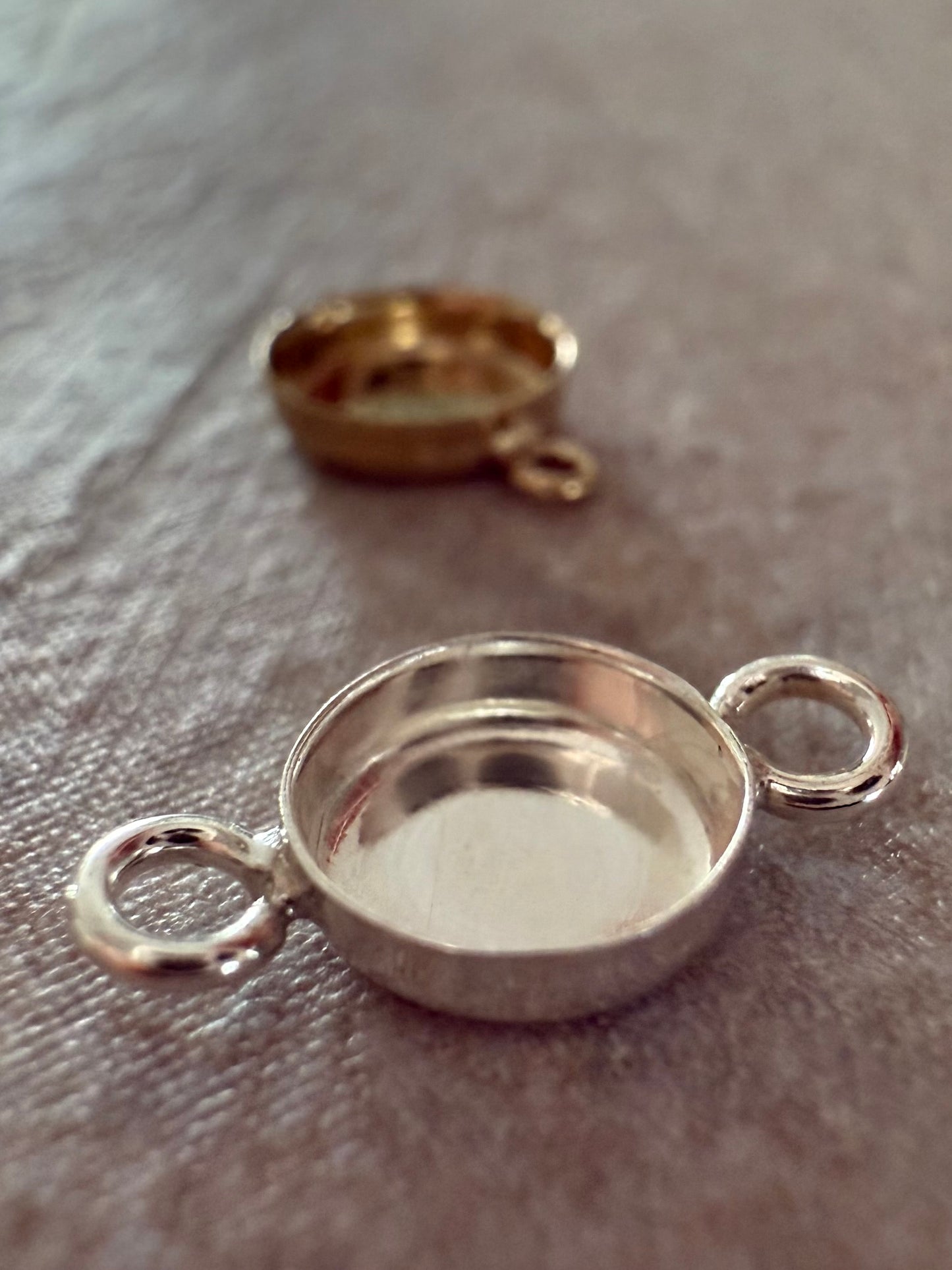 Silver and gold memorial jewelry bracelet components on a textured surface