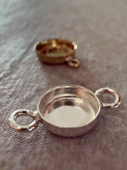 Silver and gold memorial jewelry bracelet components on a textured surface